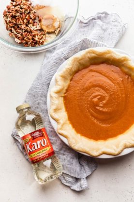 Sweet potato filling added to crimp pie dough with Karo corn syrup nearby