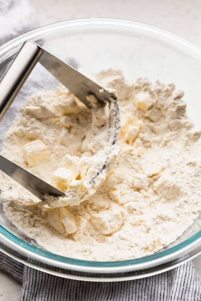 Butter being added to dry ingredients being mixed together