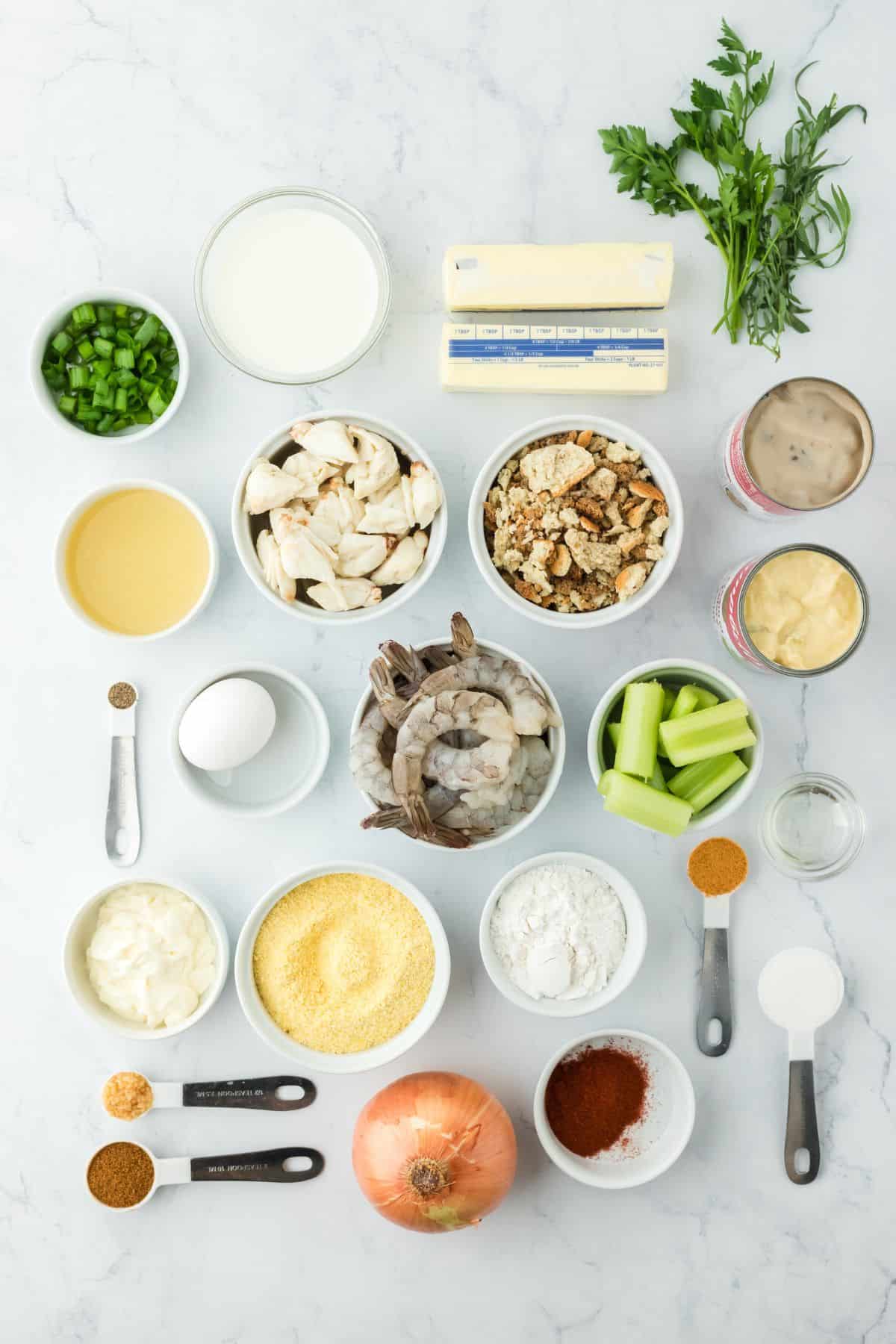 Overhead shot of ingredients to make seafood dressing on a white surface before mixing