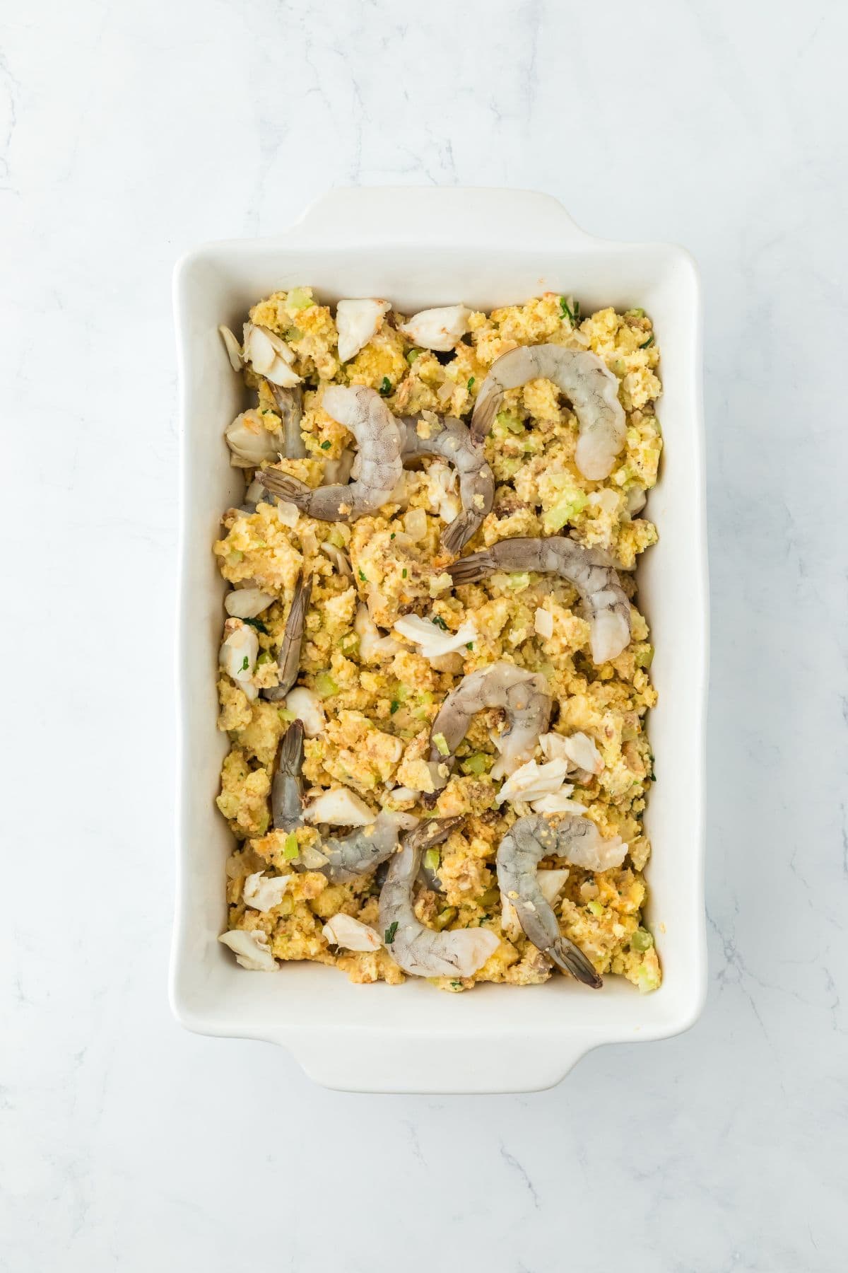 Unbaked seafood dressing in a baking dish