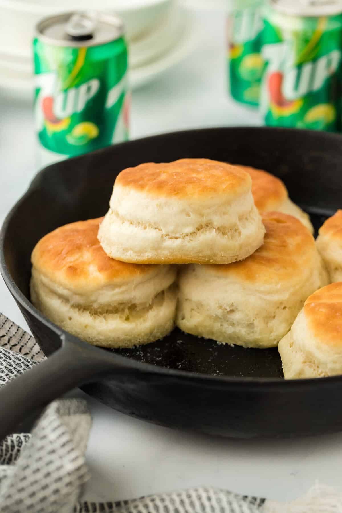 7 up biscuits in a cast iron skillet with cans of 7up in background