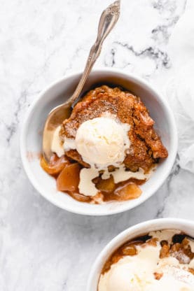 A large bowl of apple cobbler with vanilla ice cream