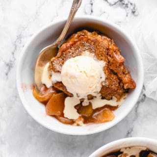 A large bowl of apple cobbler with vanilla ice cream