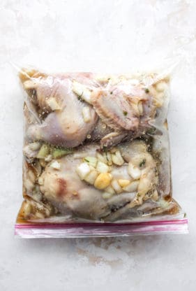Two small chickens in a plastic bag along with marinade