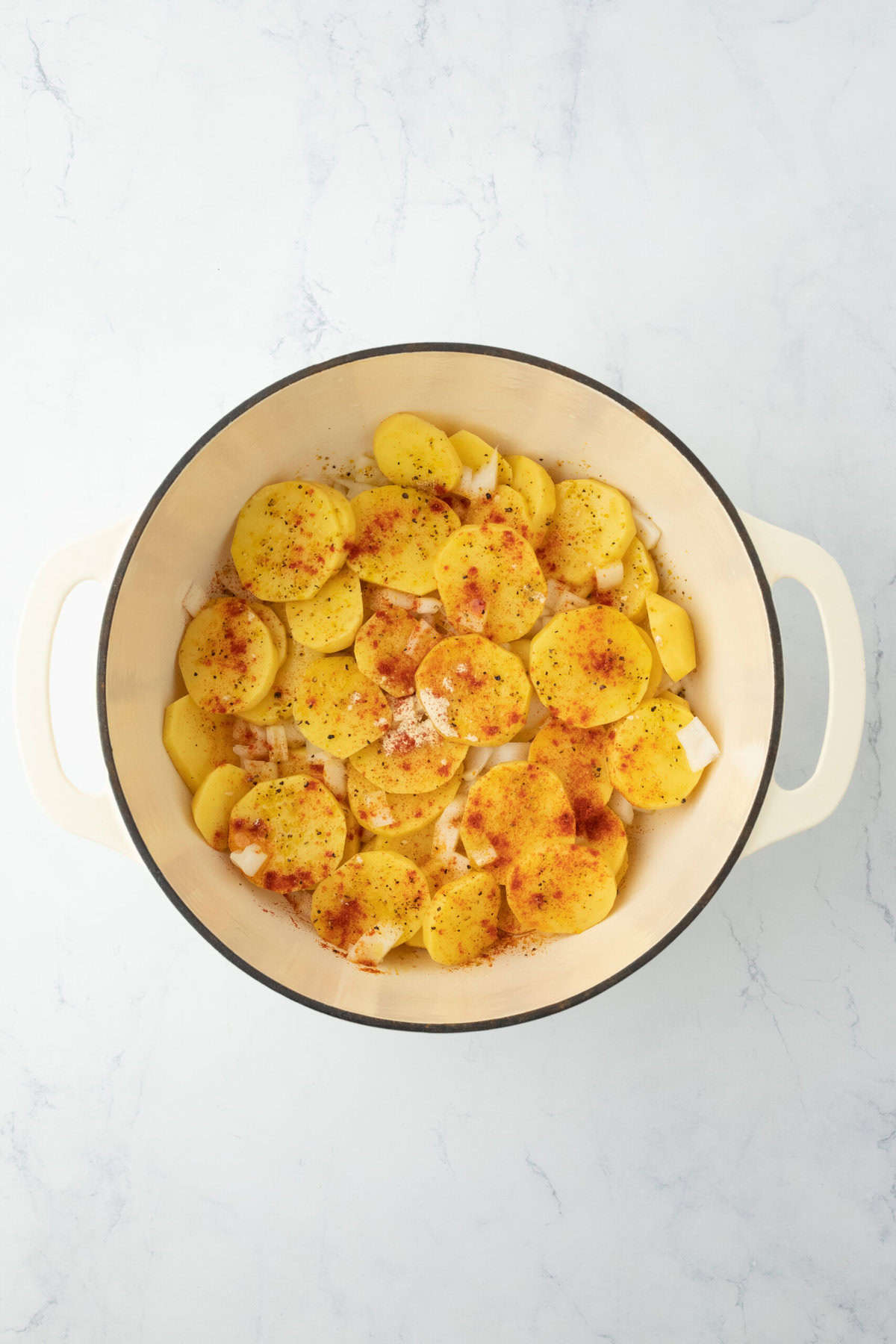 Seasoned potatoes and onions in a dutch oven