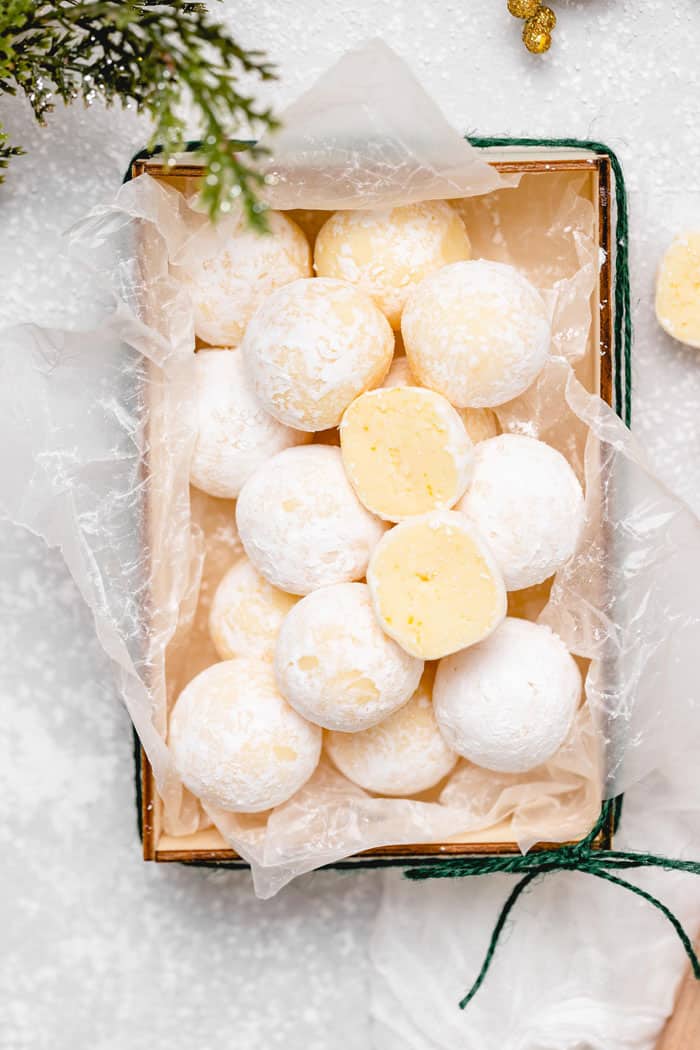 Orange white chocolates covered in powdered sugar with some cut apart to serve