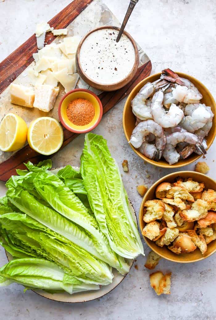 Raw shrimp, croutons, and other ingredients for a salad