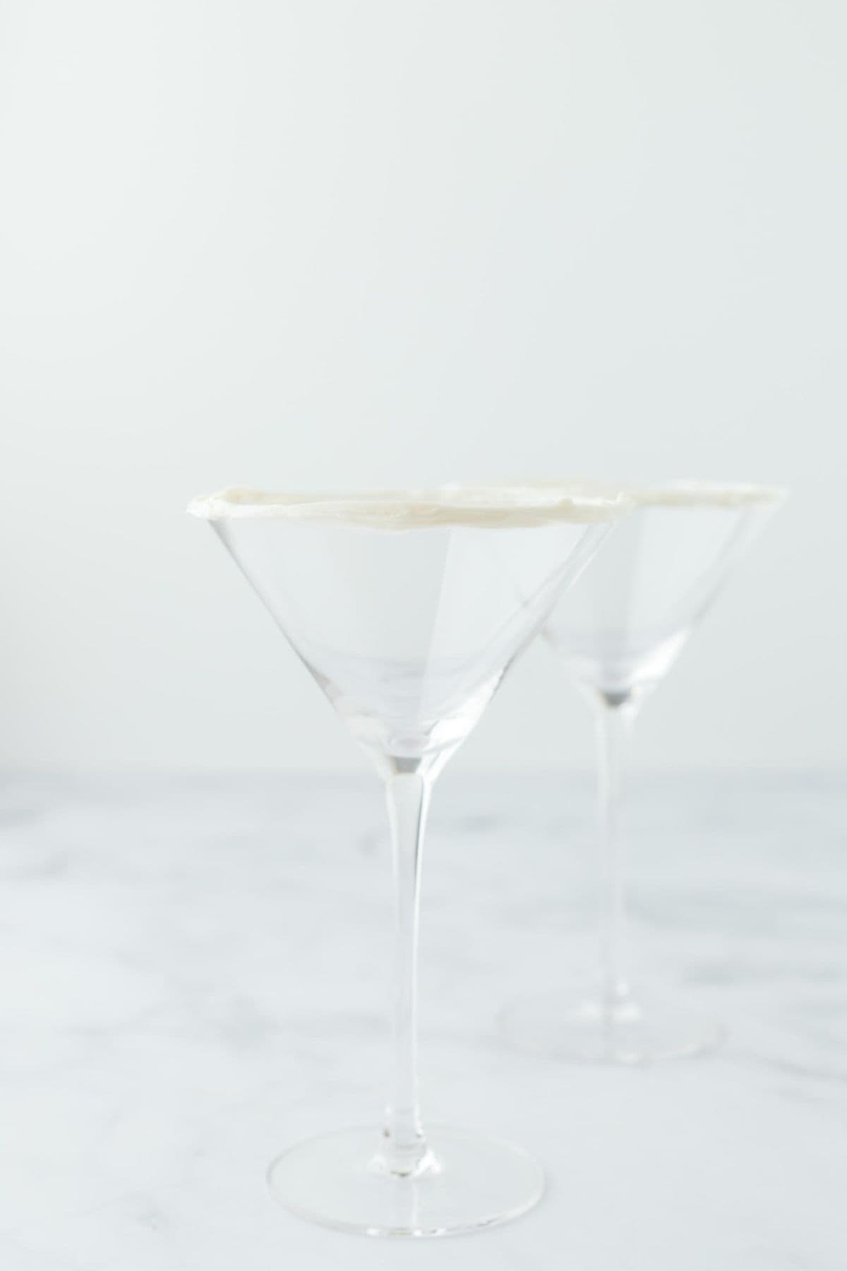 Two martini glasses with a light frosting coating around the rims