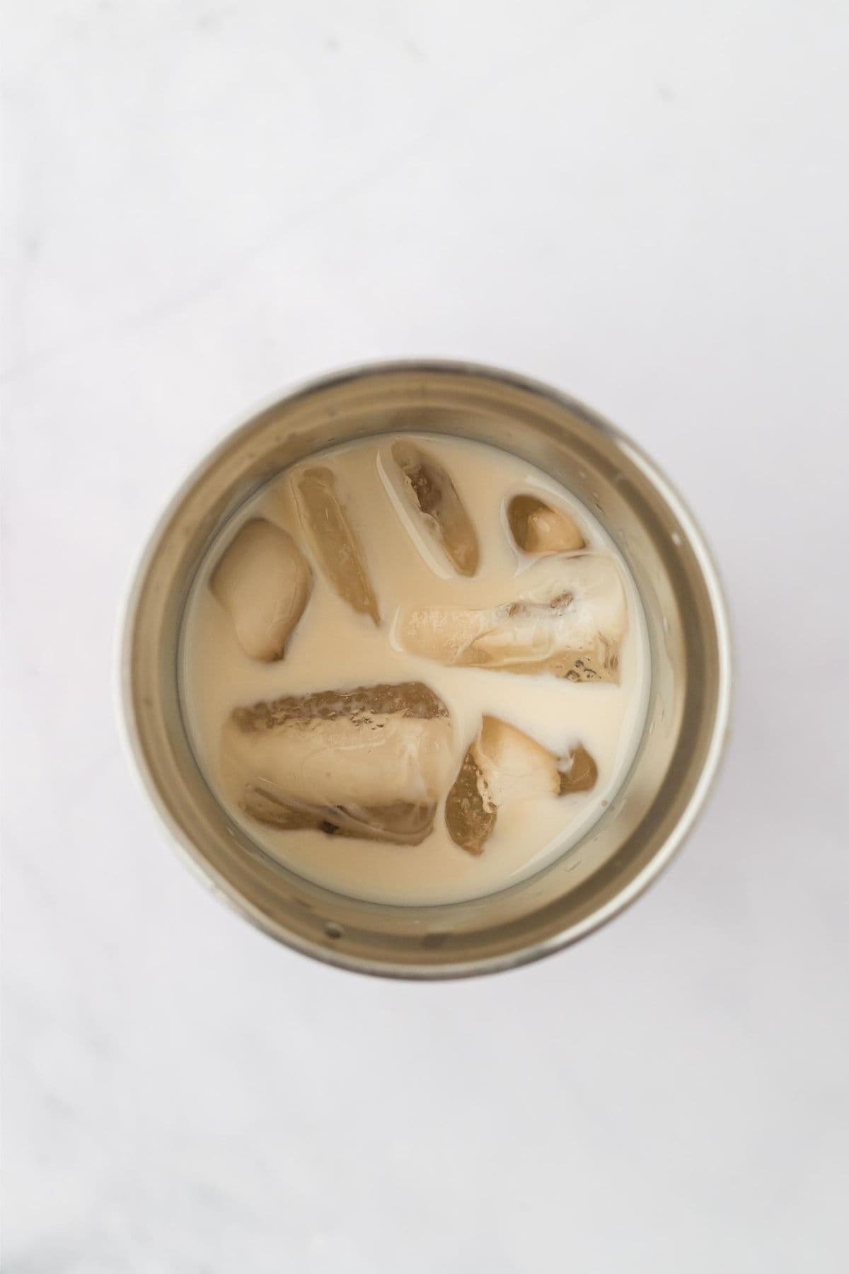 Overhead shot of a silver cocktail shaker with ice and sugar cookie martini mixture inside