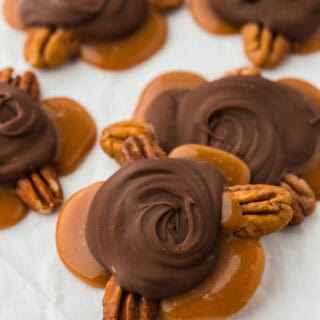 Turtle candy scattered on a white piece of parchment paper ready to enjoy