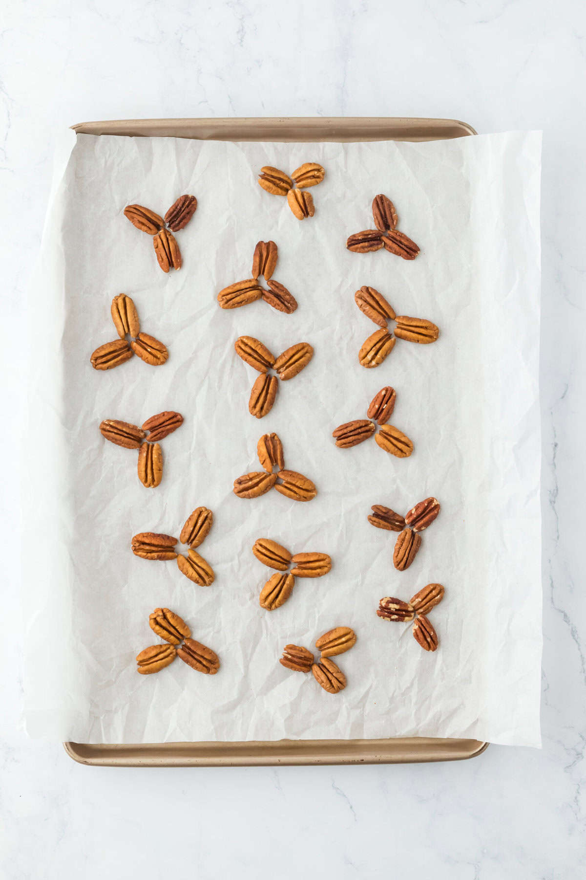 Nuts positioned in groupings on parchment paper