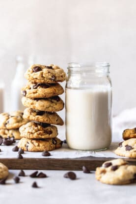A stack of high altitude baked cookies next to a jar of milk ready to enjoy