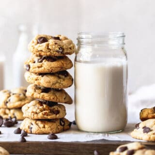 A stack of high altitude baked cookies next to a jar of milk ready to enjoy