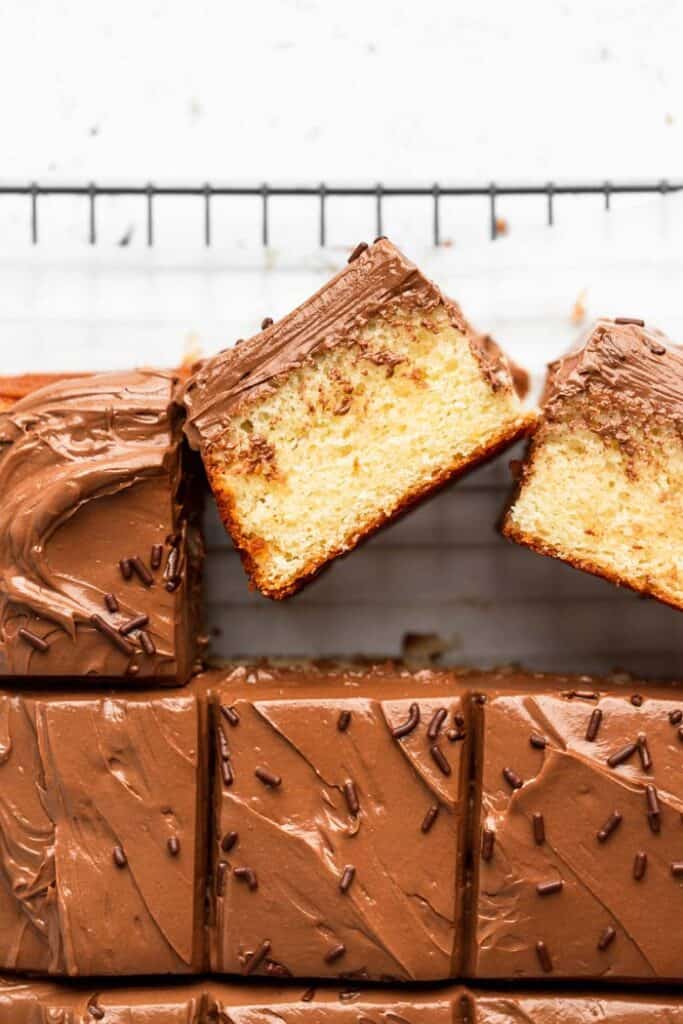 A sheet cake being spread with chocolate buttercream