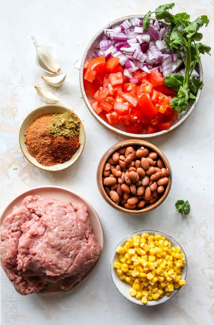 Ingredients like corn, beans and tomatoes in bowls ready to make a simple soup with taco flavors 