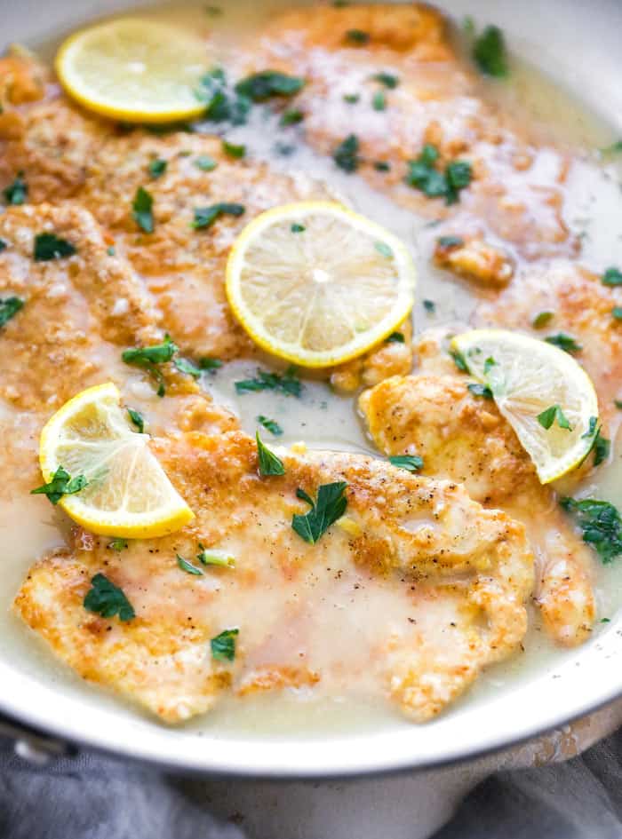 Battered chicken in pan with lemon sauce sauteing to serve