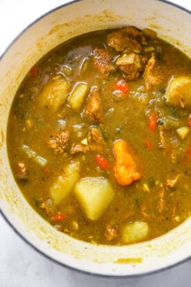 A Jamaican curry chicken stew being simmered in a large pot