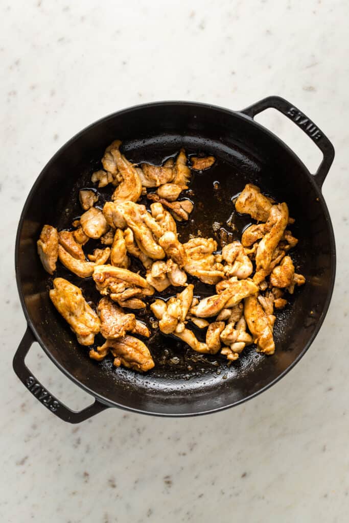 Blackened seasoned chicken in a cast iron skillet