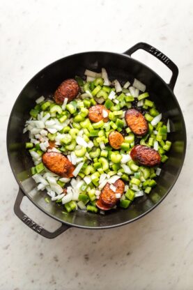 Green pepper and onion sauteed in pan with sausage