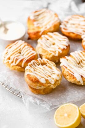 A close up of biscuit rolls with lemon filling and drizzles of lemon icing