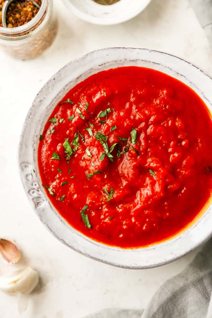 A large white bowl of red tomato sauce ready to serve