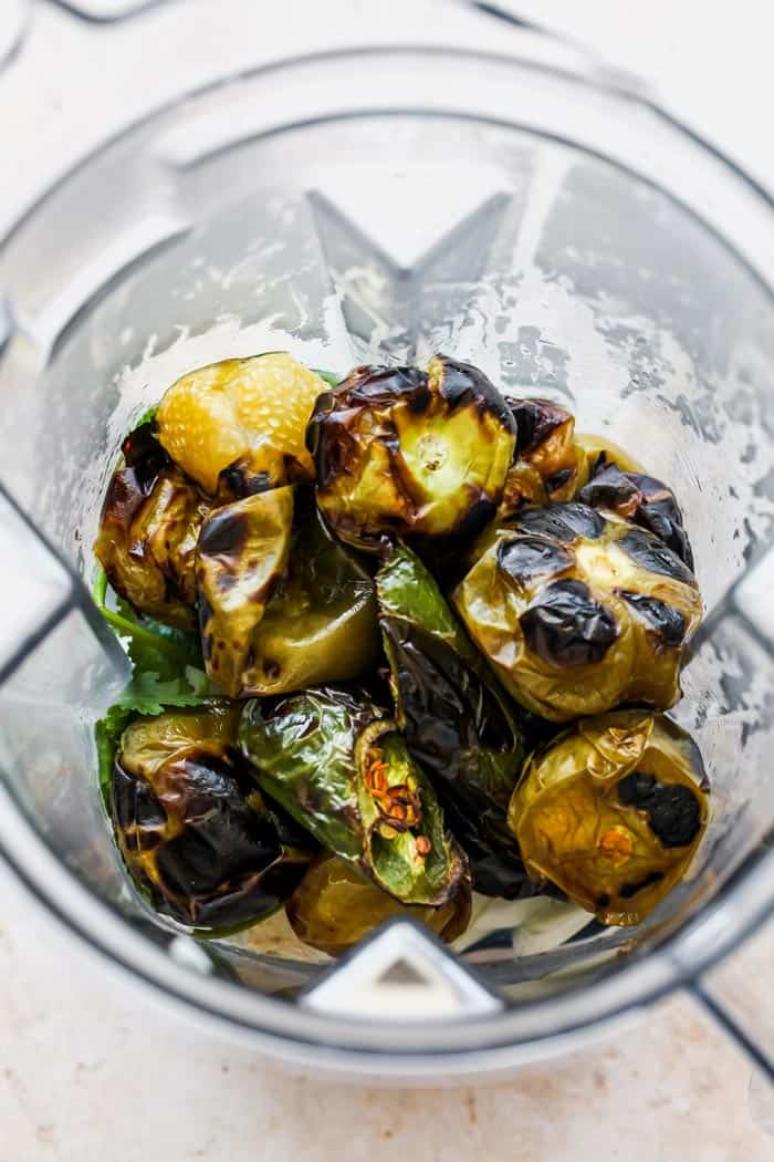 Roasted peppers and tomatillos in a heavy duty blender before blending