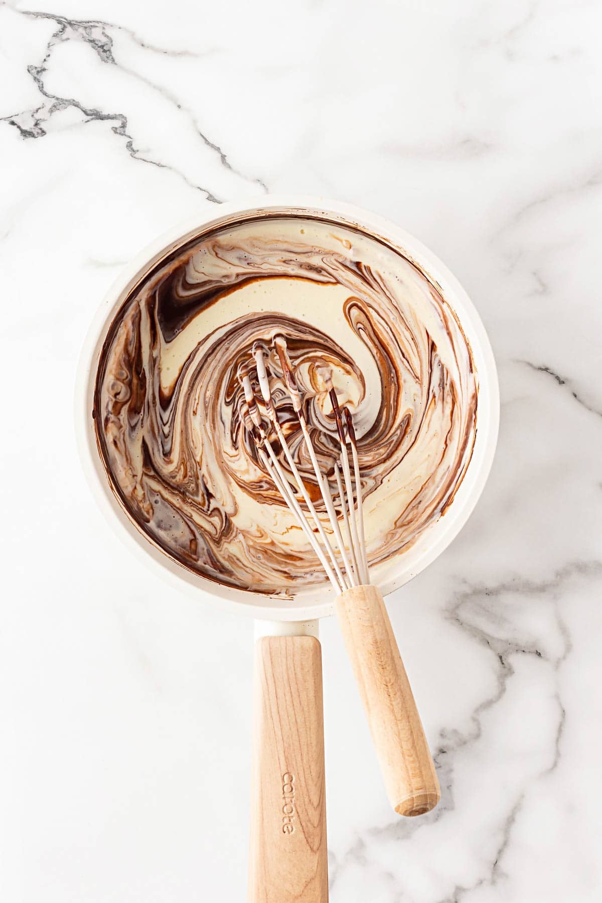 Chocolate mixture being swirled into the cream cheese base with a whisk