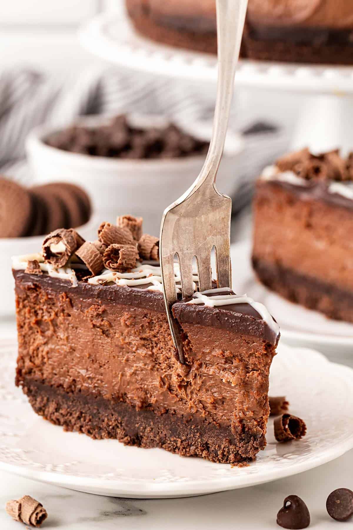 Fork taking a bite out of a slice of a chocolate cheesecake
