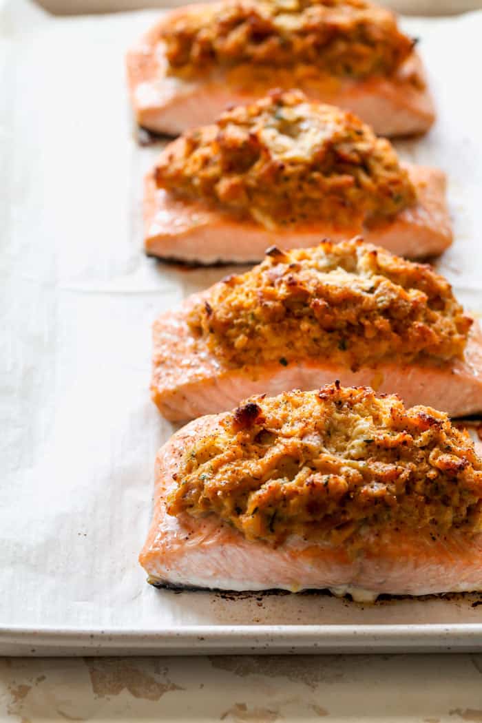 Fillets of salmon stuffed with crab filling on a parchment paper lined baking sheet after baking