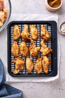 Party wings in air fryer after being cooked ready to coat in sauce