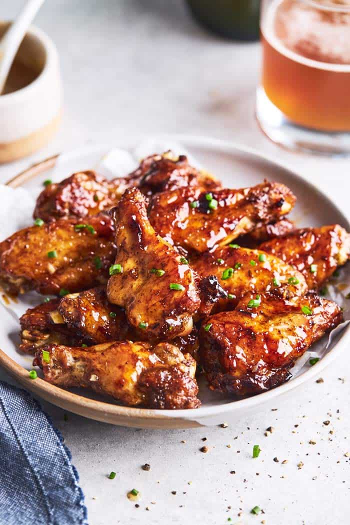 A close up of party wings with jerk seasoning and glaze on a white plate