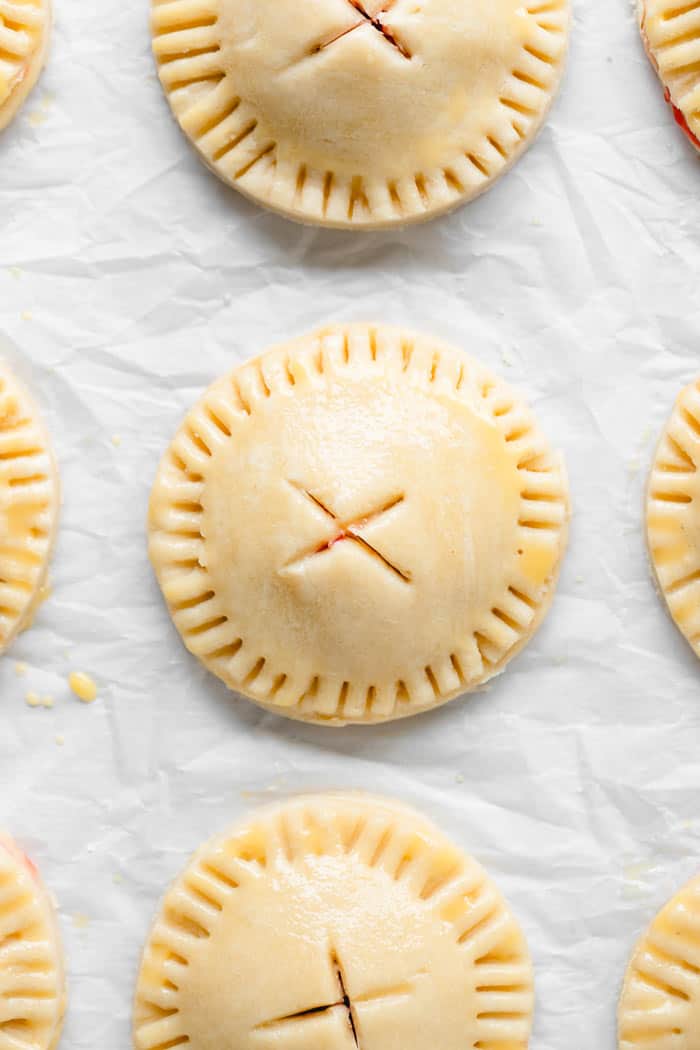 Pie dough rounds with fork crimps on the side ready to bake