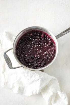 A sauce of blueberries in a medium sized pot after boiling