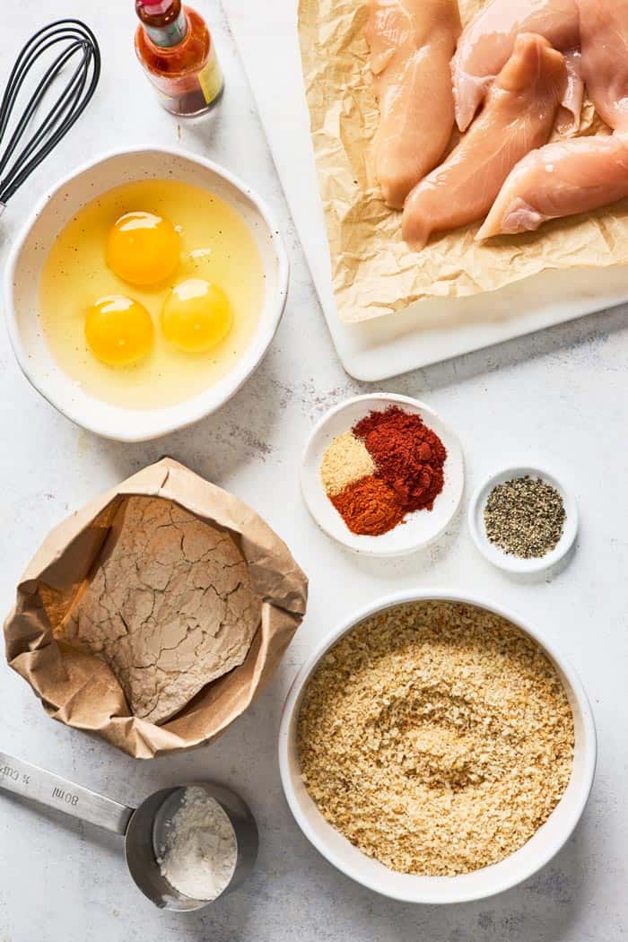 Chicken tenders, bread crumbs, spices and eggs ready to make fried chicken