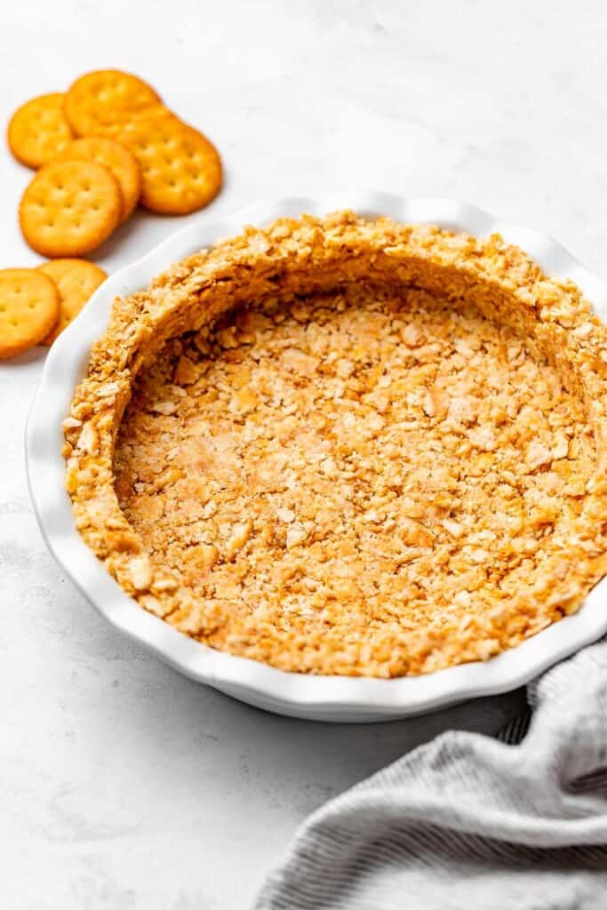 A cracker pie crust pressed into a pie plate ready to fill