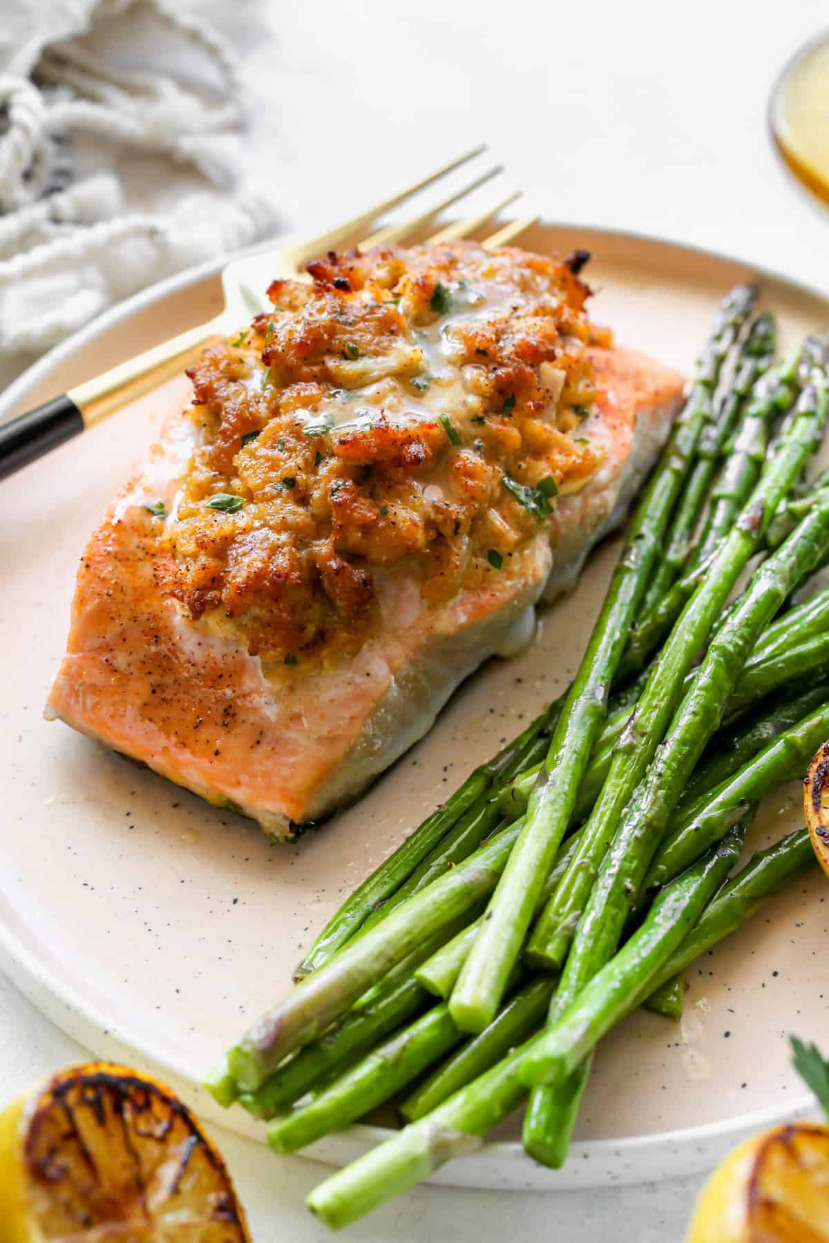 A fillet of stuffed salmon on a plate with asparagus