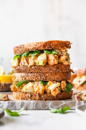 Two egg salad sandwiches stacked on top of one another