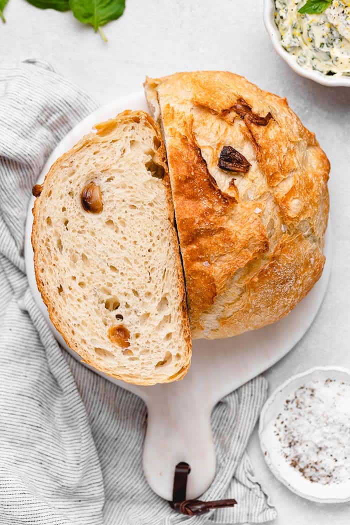 A large round of no knead bread with pieces cut
