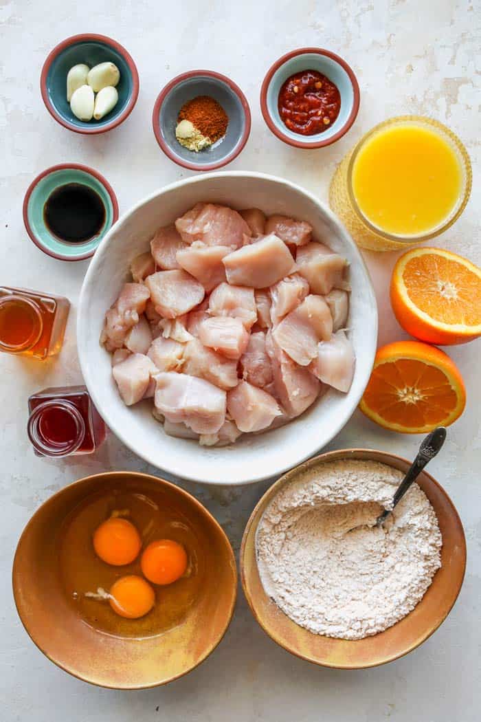 Chicken breast pieces, egg yolks, flour, oranges and other ingredients for asian dish