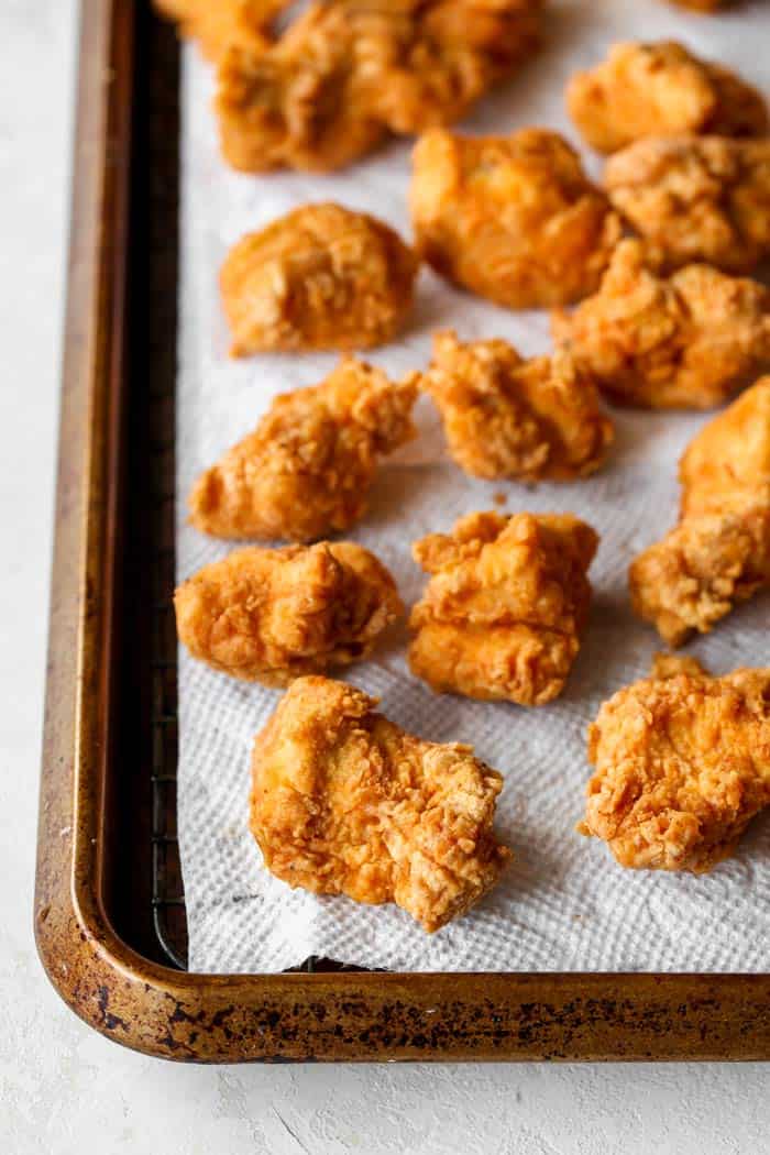 Small bites of fried chicken on a paper towel being drained