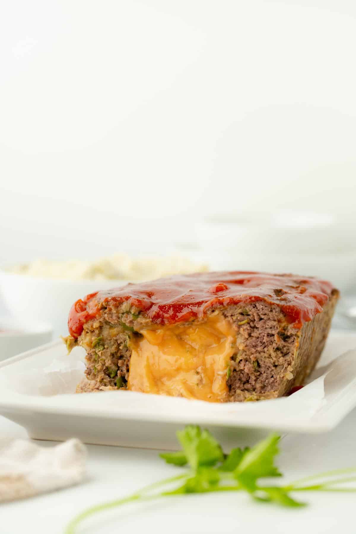 Close-up of a stuffed meatloaf slice with cheese oozing out