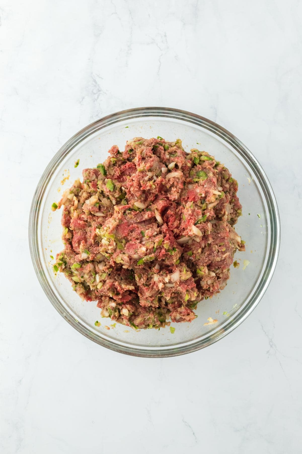 Combined and mixed ingredients for stuffed meatloaf in a glass bowl