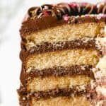 A close up of a sliced yellow birthday cake with sprinkles on top