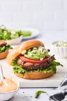 One chipotle black bean burger with cheese, avocado and tomato on a bun ready to enjoy