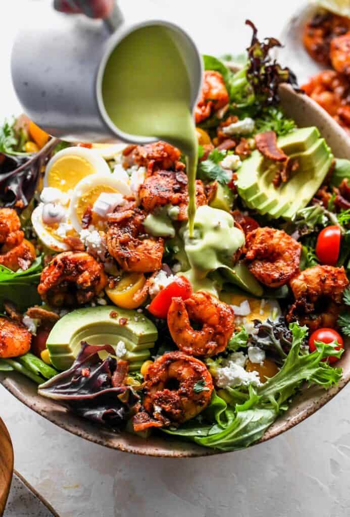 Dressing being poured over salad