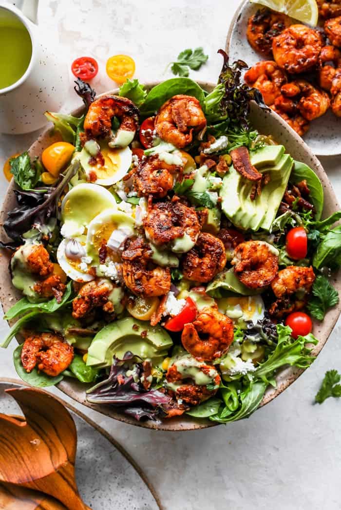 A close up of shrimp salad with boiled eggs, avocado and mango dressing