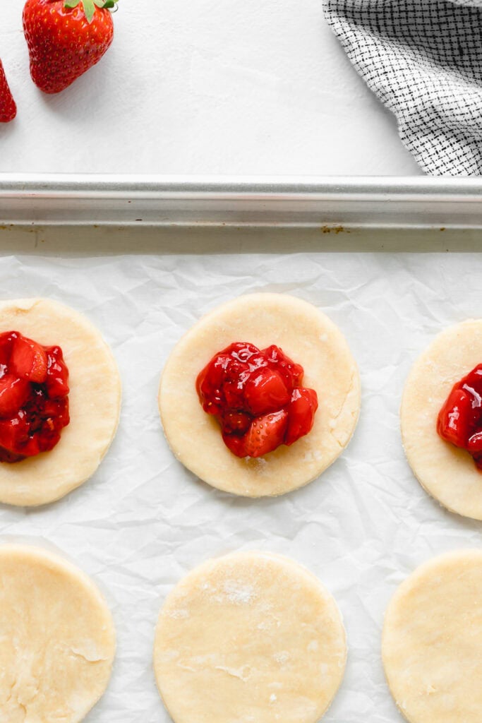 Strawberry filling spooned on top of pie rounds