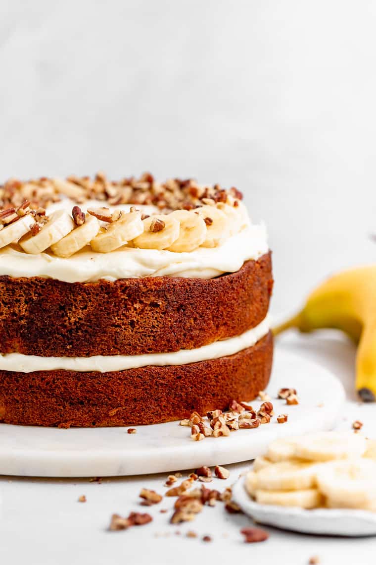 A delicious two layer cake with mashed bananas in the batter baked until golden against white background