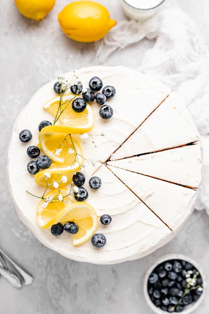 An overhead of blueberry lemon cake with slices ready to remove
