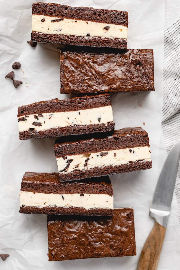 An overhead of brownie ice cream sandwiches against a white background